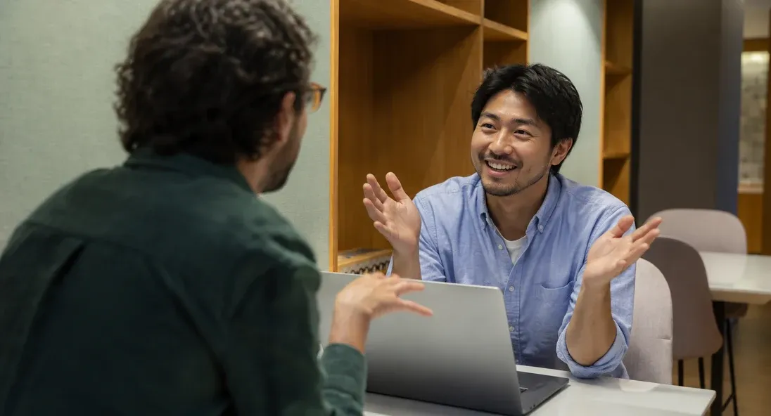 Two colleagues discussing business operations across a table